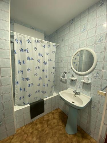 a bathroom with a sink and a mirror and a shower curtain at El rincón del Corneja in Villafranca de la Sierra