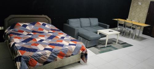 a bedroom with a bed and a chair and a table at Private Room with Separate Bathroom and balcony in Ajman 