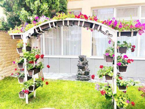 a pergola filled with flowers in a yard at Hotel Bulevard Prestige in Slatina