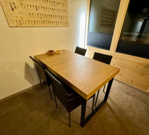 a wooden table and chairs in a room at Ferienwohnung Brunni-Lodge am Grossen Mythen in Alpthal