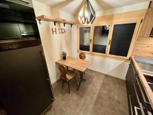 a kitchen with a table and a happy sign on the wall at Ferienwohnung Brunni-Lodge direkt am Grossen Mythen in Alpthal