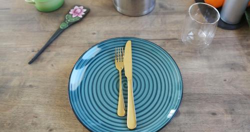 una piastra blu con una forchetta e un coltello su un tavolo di La Boheme Casa Rural a Murchas