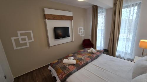 a bedroom with a bed with two towels on it at Jafar Resort 3 in Timişoara