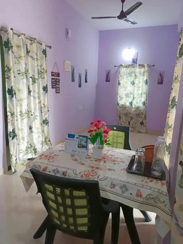 a dining room with a table with flowers on it at Michelle Residency in Rourkela