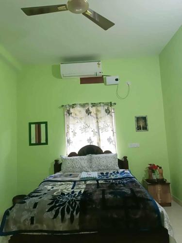a green bedroom with a bed and a window at Michelle Residency in Rourkela