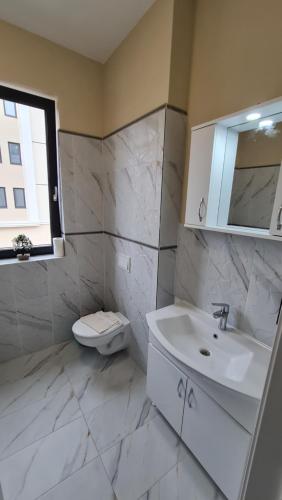 uma casa de banho branca com um lavatório e um WC em Jafar Resort 3 em Timisoara