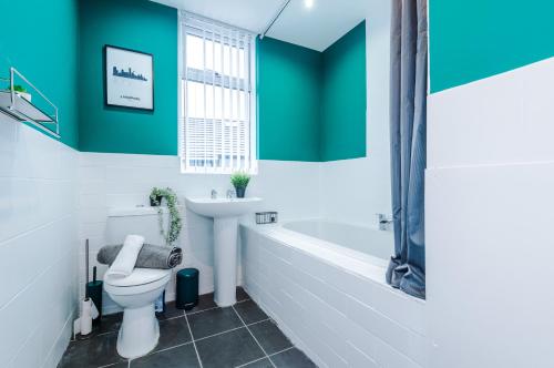 a bathroom with a tub and a toilet and a sink at Stunning 3-bed home in Anfield by 53 Degrees Property, Ideal For Big Groups, FREE parking! in Liverpool