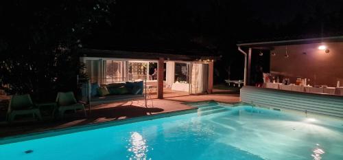 una piscina en un patio por la noche en La Villa des Violettes, en Toulouse