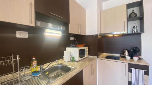 a kitchen with a sink and a microwave at Bratanov Summer Apartment in Sunny Beach