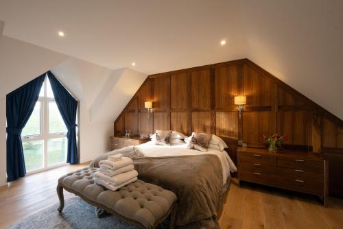 - une chambre avec un grand lit et une grande fenêtre dans l'établissement Robin Cottage, à Buchanty