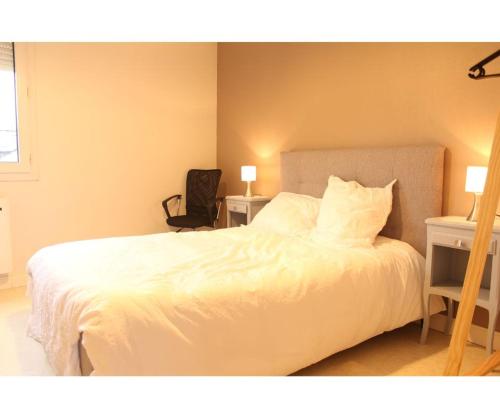 勒芒的住宿－Flexy - T2 - L' Agate Grise - Le Mans，卧室配有白色的床、两张桌子和椅子