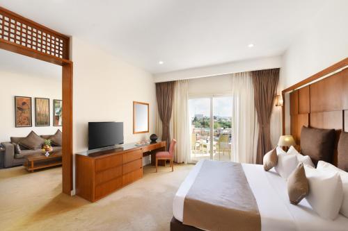 a hotel room with a bed and a television at Tolip Family Park Hotel in Cairo