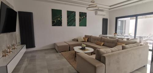 Villa B&B في سوسة: غرفة معيشة مع أريكة وطاولة