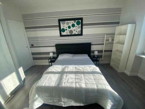 a bedroom with a large bed with striped walls at FRESH HOME in Turin