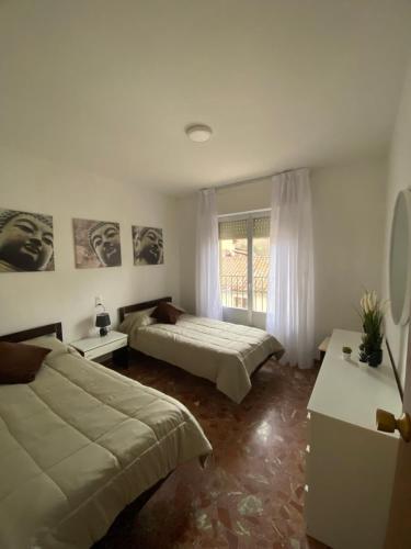 1 dormitorio con 2 camas y ventana en El rincón del Corneja, en Villafranca de la Sierra