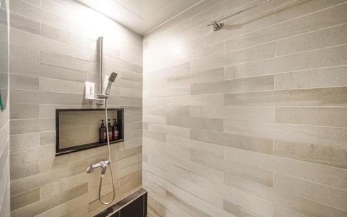 a bathroom with a shower with a tv on the wall at Hotel Yaja Siheung Jeongwang Branch in Siheung