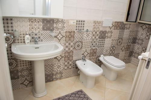 uma casa de banho com um lavatório e um WC em RV CASA VACANZE em Vignacastrisi