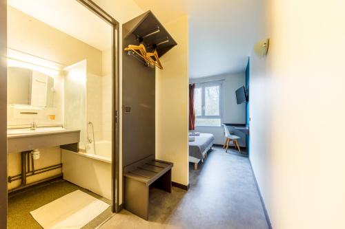 uma casa de banho com um lavatório e um espelho num quarto em Hôtel La Nonette ASTERIX, CDG AIRPORT & PARIS CENTRE em Orry-la-Ville
