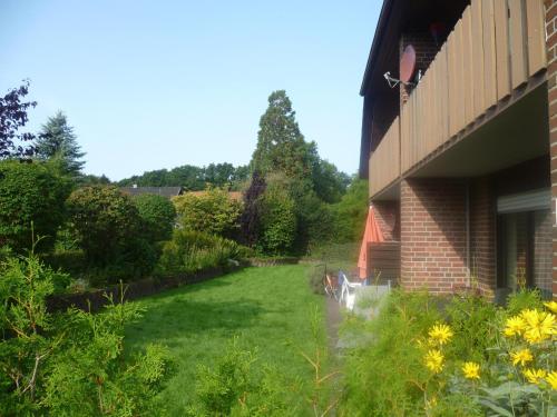 a garden next to a house with a lawn at Ferienwohnung Hoffmann, FeWo Vermittlung Nordsee in Dangast