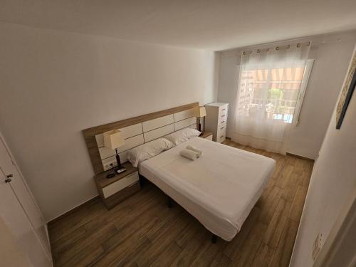 a bedroom with a white bed and a window at Falcon (Beach & Golf) in Playa de San Juan