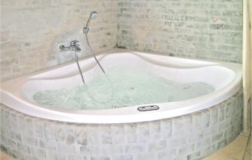 a bath tub filled with water in a bathroom at Awesome Home In Dannemare With 3 Bedrooms, Sauna And Wifi in Dannemare