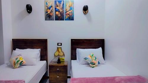 2 camas en una habitación con paredes blancas en Sama Stars Hotel en Abu Simbel