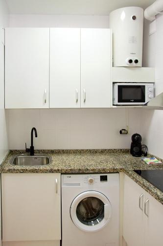 a kitchen with a sink and a washing machine at Precioso piso residencial in Seville