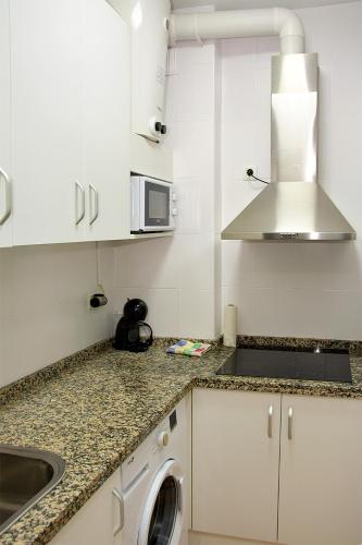 a kitchen with a sink and a washing machine at Precioso piso residencial in Seville