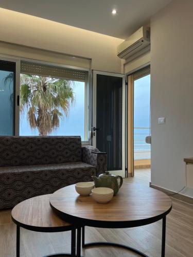 een woonkamer met een tafel en een bank bij SKetch Apartments in Durrës
