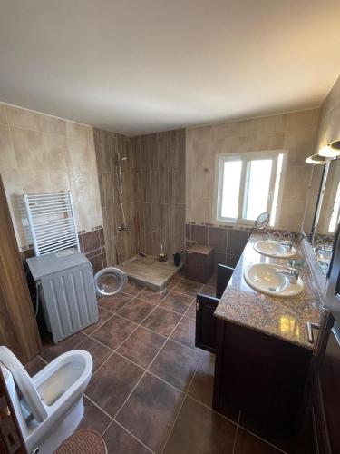 een grote badkamer met 2 wastafels en een toilet bij SakEn PrivateVilla Kıbrıs Girne KKTC Kyrnea Cypurs in Edremit