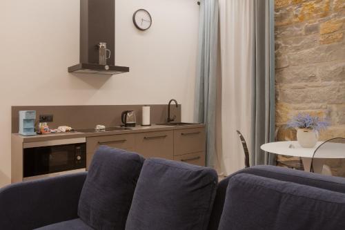 a kitchen with two blue chairs and a table at San Nicolò Suites in Trieste