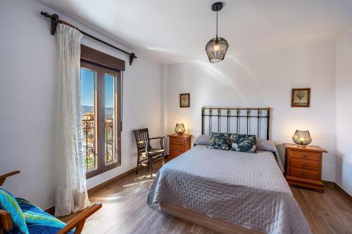 a bedroom with a bed and a large window at Coqueta casa rural para 8 personas in Nigüelas