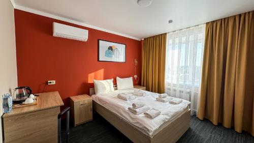 una camera d'albergo con letto e finestra di Отель KOKSHETAU a Kökşetaw