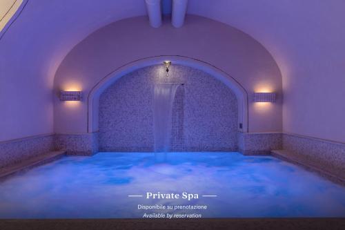 una piscina de agua azul en una habitación púrpura en TB Place Roma en Roma