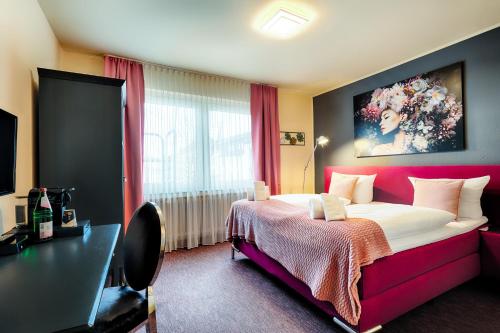 a bedroom with a large bed with a red headboard at Hotel Fürst Garden in Dortmund