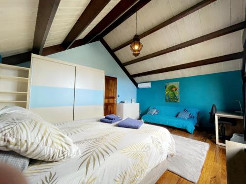 um quarto com 2 camas e uma parede azul em Villa Hermès Chambre bleue océan em Saint-Pierre