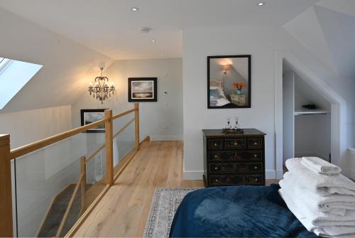 sypialnia z niebieskim łóżkiem i schodami w obiekcie Oystercatcher - Converted luxury steading w mieście Perth