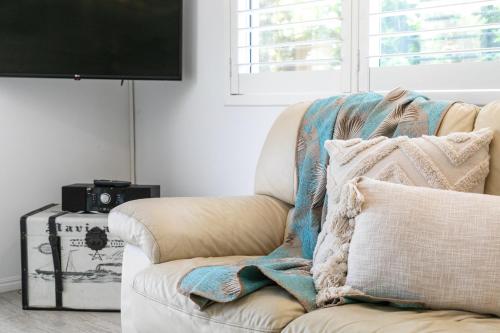 a living room with a couch and a tv at Noosa Sunseeker-walk to cafes & river, pet friendly in Noosaville