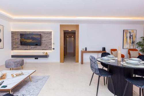 una sala de estar con una mesa y sillas en Aristocratic Abode: Luxurious 2BR Flat in Agdal, en Rabat