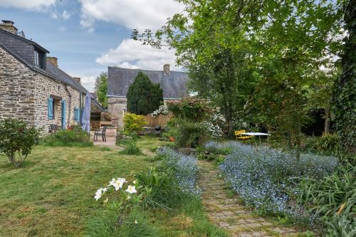 a garden with blue flowers in front of a building at Ville Moizo in Sérent