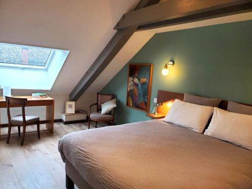 a bedroom with a bed and a table and a window at Les 7 Frères in Monestier-de-Clermont