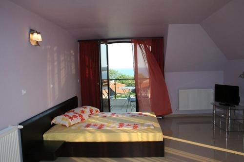 a bedroom with a bed and a large window at Silistar Hotel in Rezovo