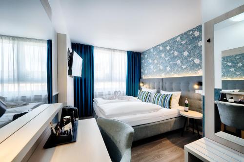 Habitación de hotel con cama y escritorio en Home Hotel, en Dortmund