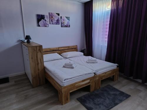 een slaapkamer met een bed met een houten frame bij Pension Eder in Bruck an der Leitha