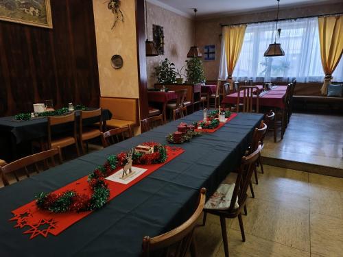 een lange tafel in een eetkamer met tafels en stoelen bij Pension Eder in Bruck an der Leitha