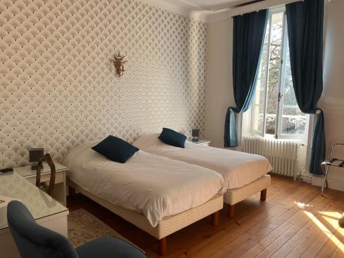 a bedroom with two beds and a window at Chateau De Mesnac, maison d hote et gites in Mesnac