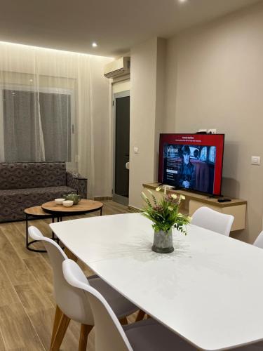 een woonkamer met een witte tafel en een tv bij SKetch Apartments in Durrës