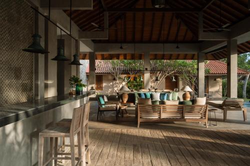 an outdoor patio with chairs and a table at Kirana - A Santani Villa in Bentota