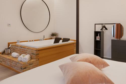 - une chambre avec une baignoire et un lit dans l'établissement San Nicolò Suites, à Trieste