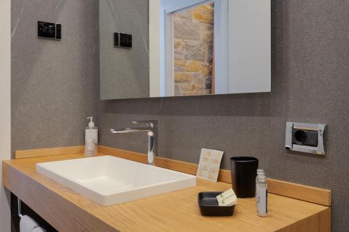 a bathroom with a white sink and a mirror at San Nicolò Suites in Trieste